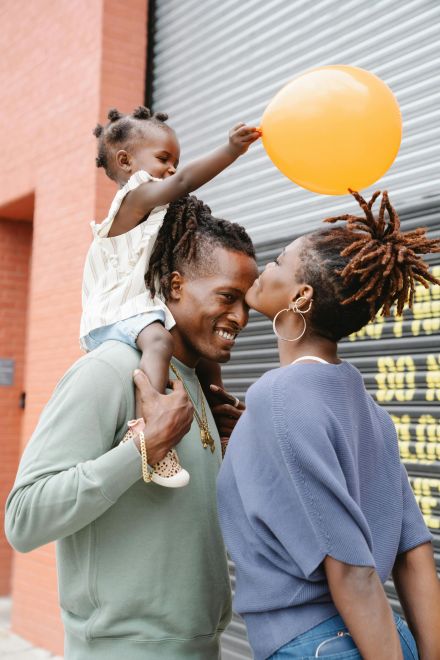 Happy family enjoying time outdoors with orange balloon